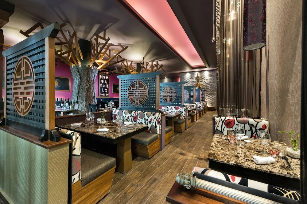 Ornate booth seating and decorative screens inside a dining room at El Dorado Seaside Suites