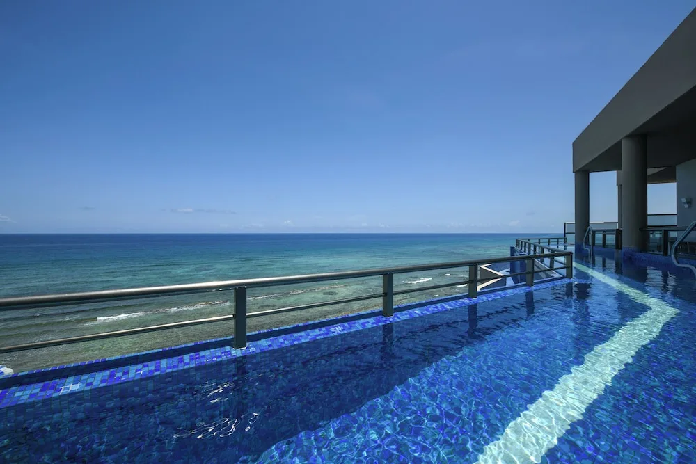Infinity pool on an upper deck overlooking the ocean at El Dorado Seaside Suites