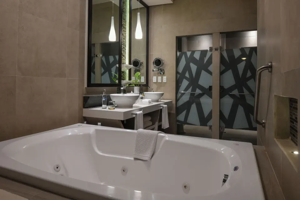 Close-up of a jetted bathtub and vanity area at El Dorado Seaside Suites