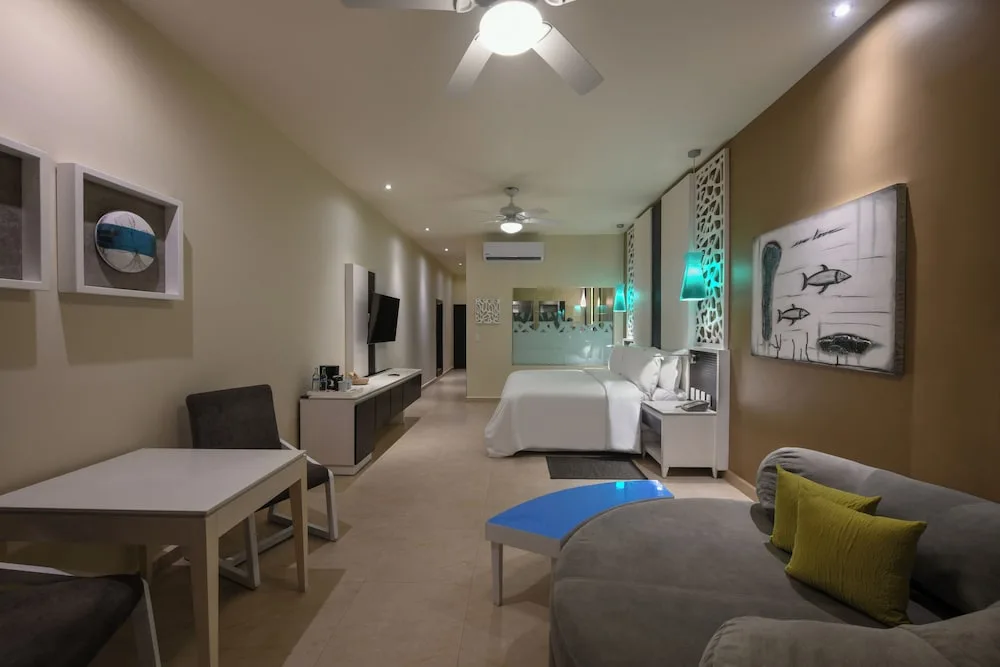 Spacious junior suite with king bed, seating and desk at El Dorado Seaside Suites.