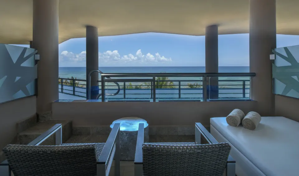 Covered balcony seating and plunge pool with sea panorama at El Dorado Seaside Suites