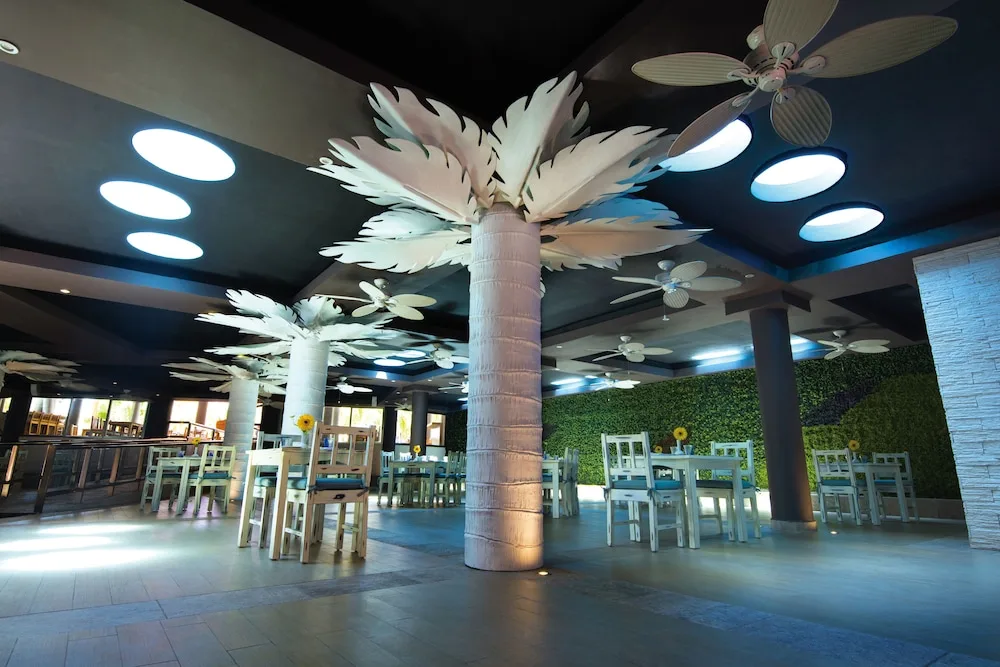 Large indoor dining area with palm column decor at El Dorado Seaside Suites