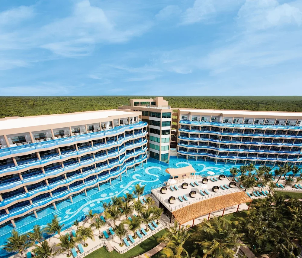 Aerial view of the resort buildings and large swimming pool at El Dorado Seaside Suites
