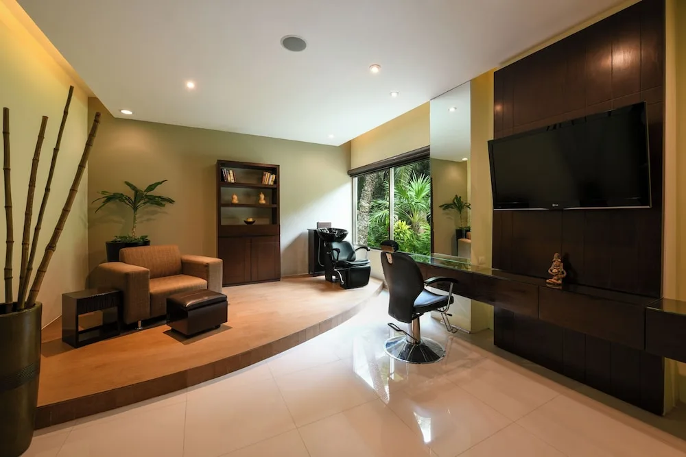 Relaxing spa salon area with treatment chair and TV at El Dorado Seaside Suites.