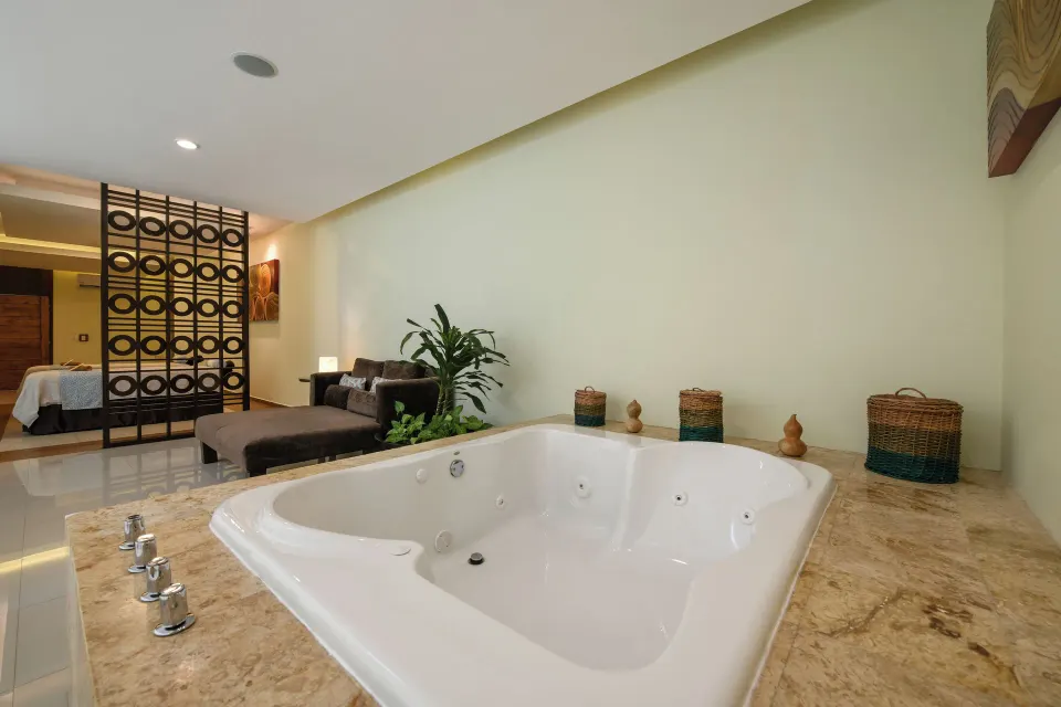 Suite interior showing a large jetted tub and bedroom area at El Dorado Seaside Suites