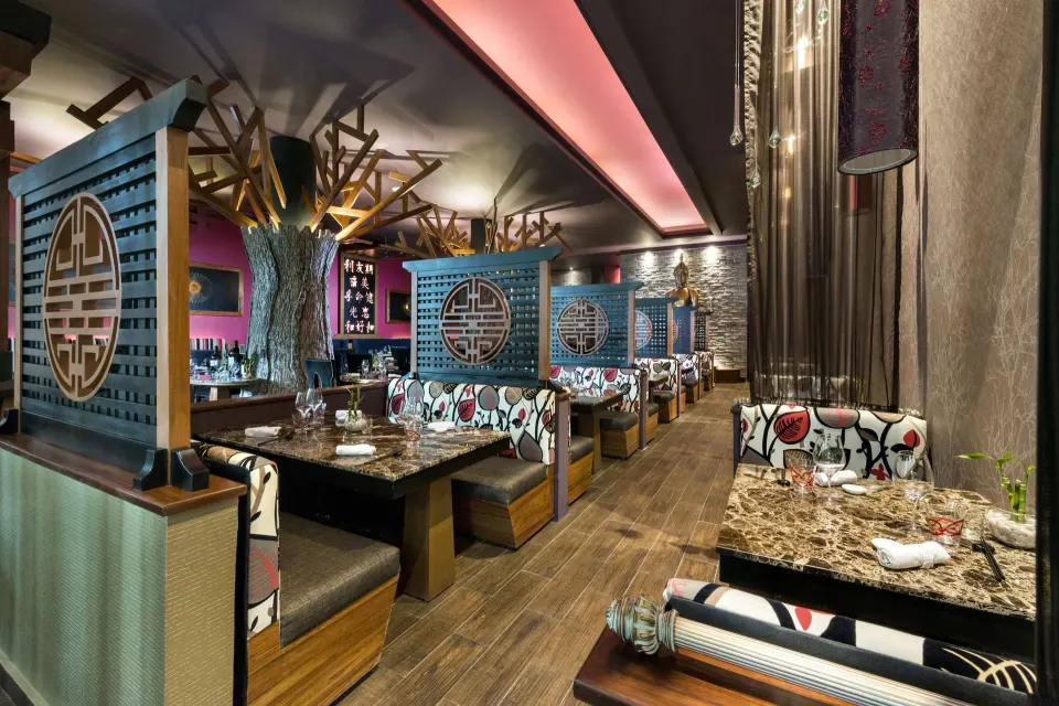 Restaurant interior with booth seating and decorative screens at El Dorado Seaside Suites