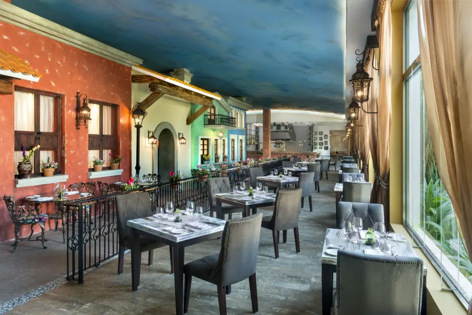 Indoor restaurant dining room with colorful facades at El Dorado Seaside Suites