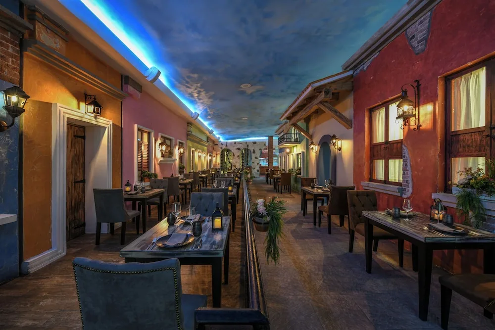 Indoor courtyard-style restaurant with colorful facades at El Dorado Seaside Suites