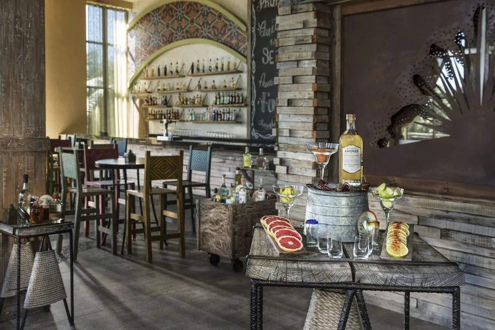 Interior view of a bar area with bottles and seating at El Dorado Seaside Suites