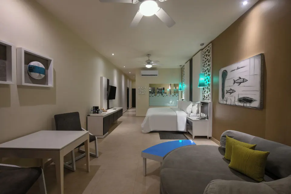 Wide-angle view of Oceanfront Upper Swim Up Suite showing beds, seating and TV at El Dorado Seaside Suites