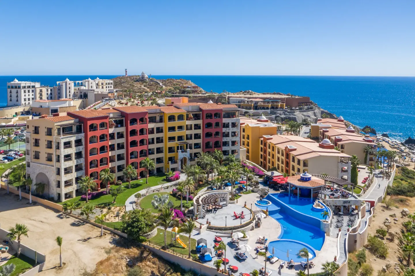 Aerial view of colorful resort buildings, pools and the ocean at El Encanto at Hacienda Encantada.