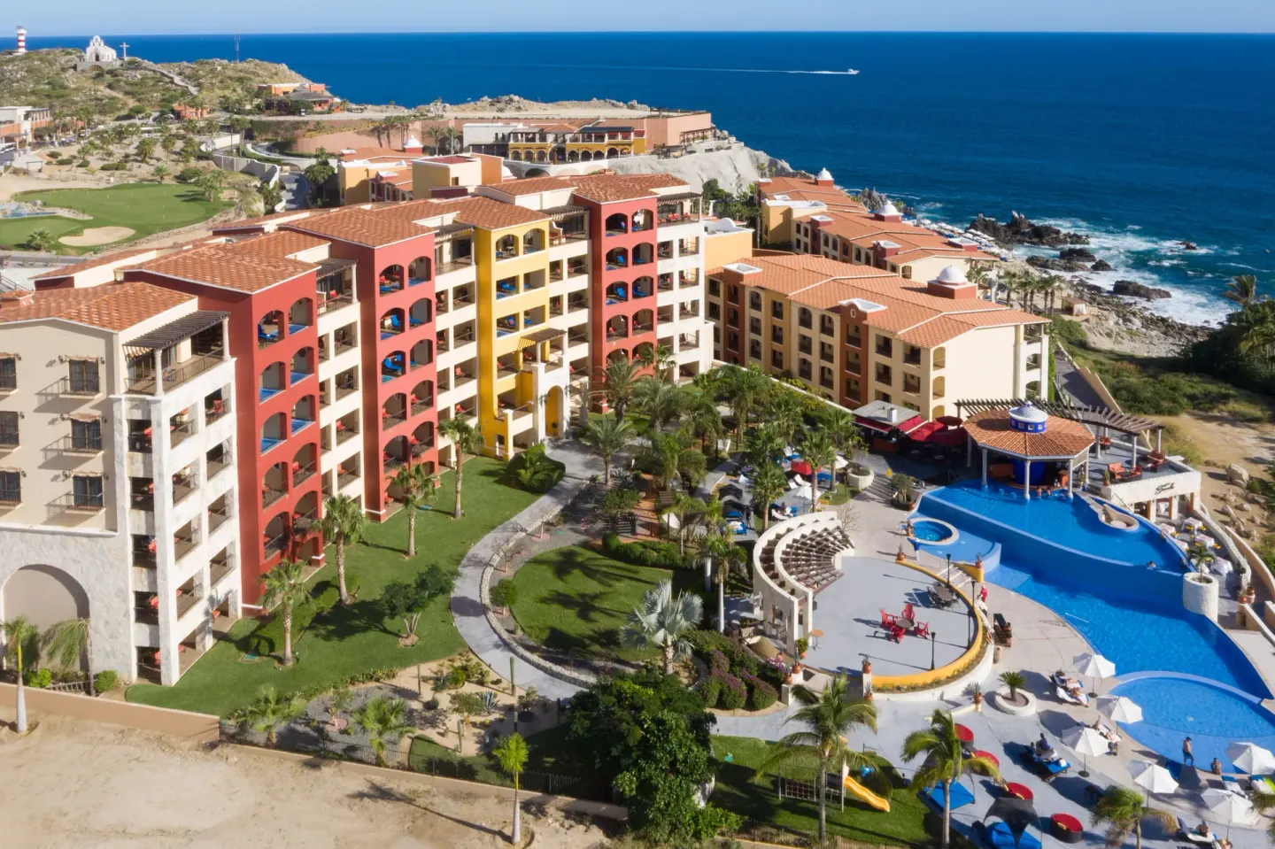 Aerial view of resort buildings, lawns and a pool by the sea at El Encanto at Hacienda Encantada.