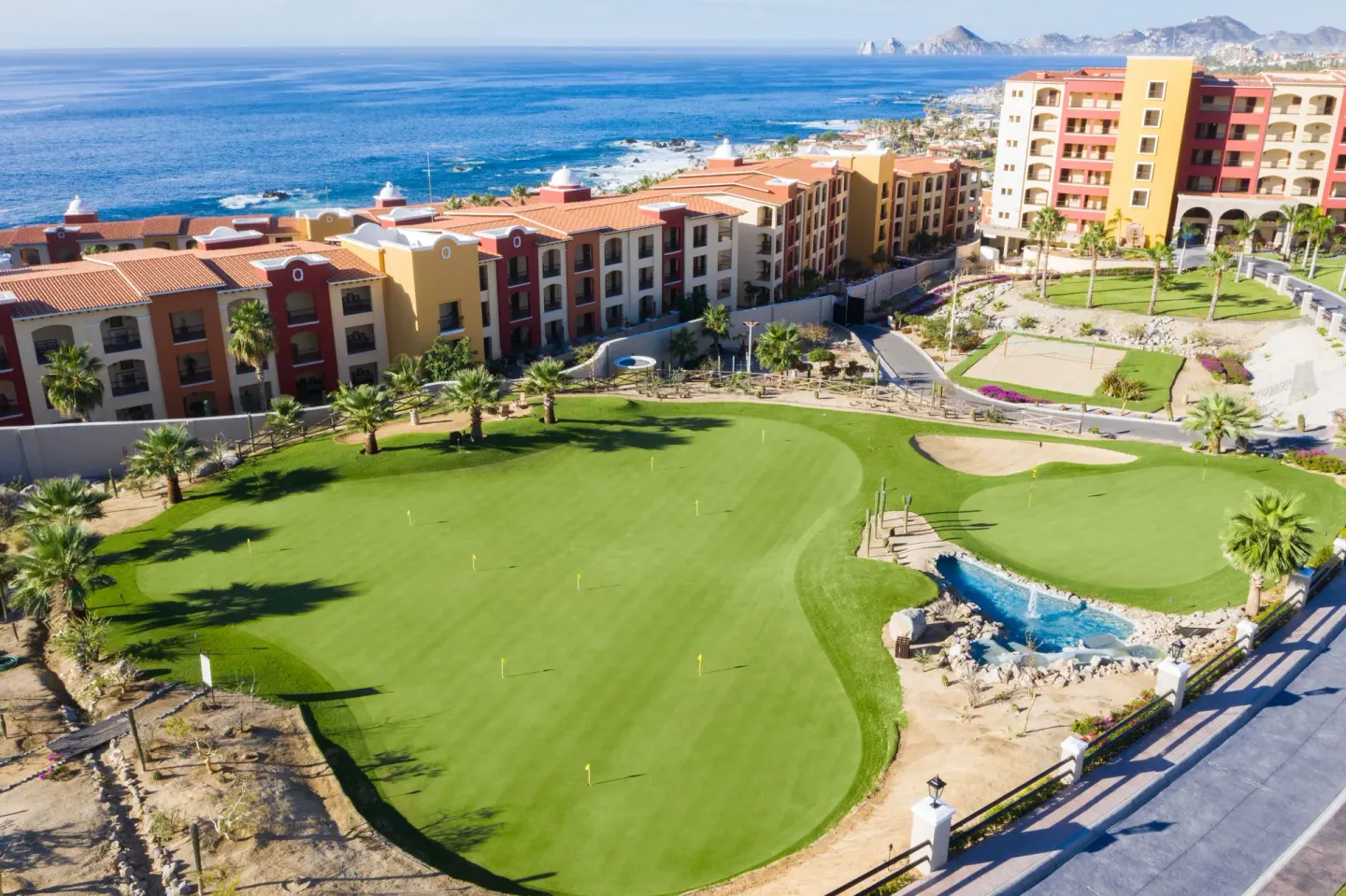 Aerial resort grounds with golf greens and ocean at El Encanto at Hacienda Encantada