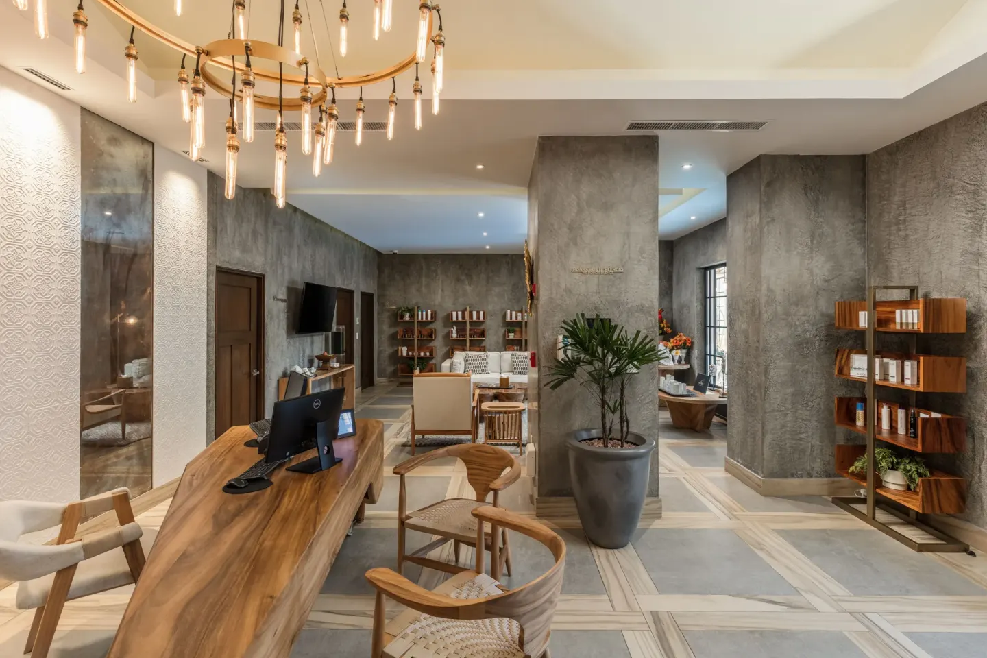 Spa reception lounge with wood desk and product shelves at El Encanto at Hacienda Encantada.