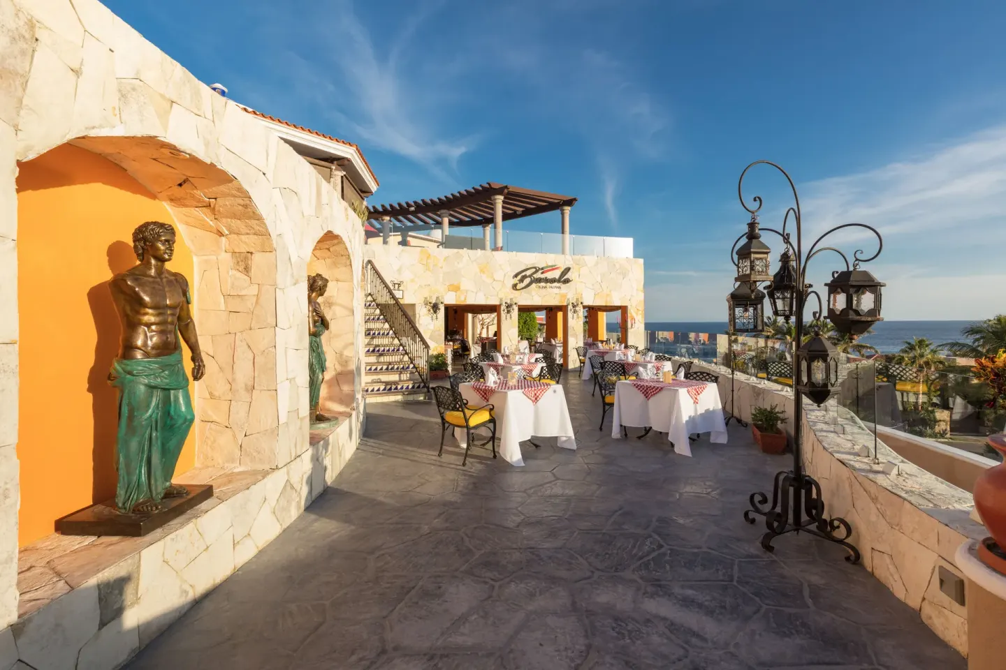 Barolo terrace at El Encanto at Hacienda Encantada with statues, white tablecloths, and ocean views.