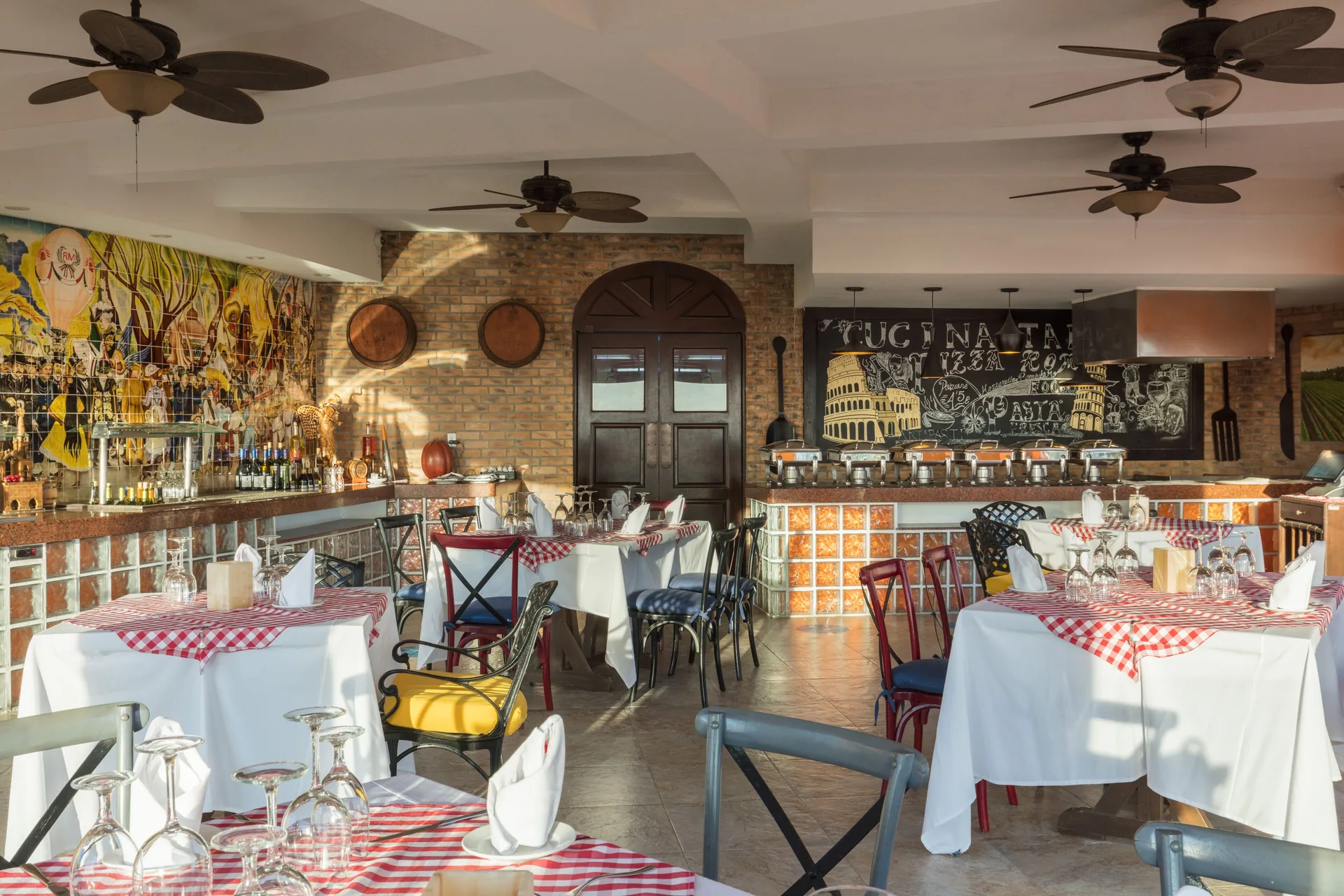 Italian-style dining room at El Encanto at Hacienda Encantada with checkered tablecloths and buffet counter.
