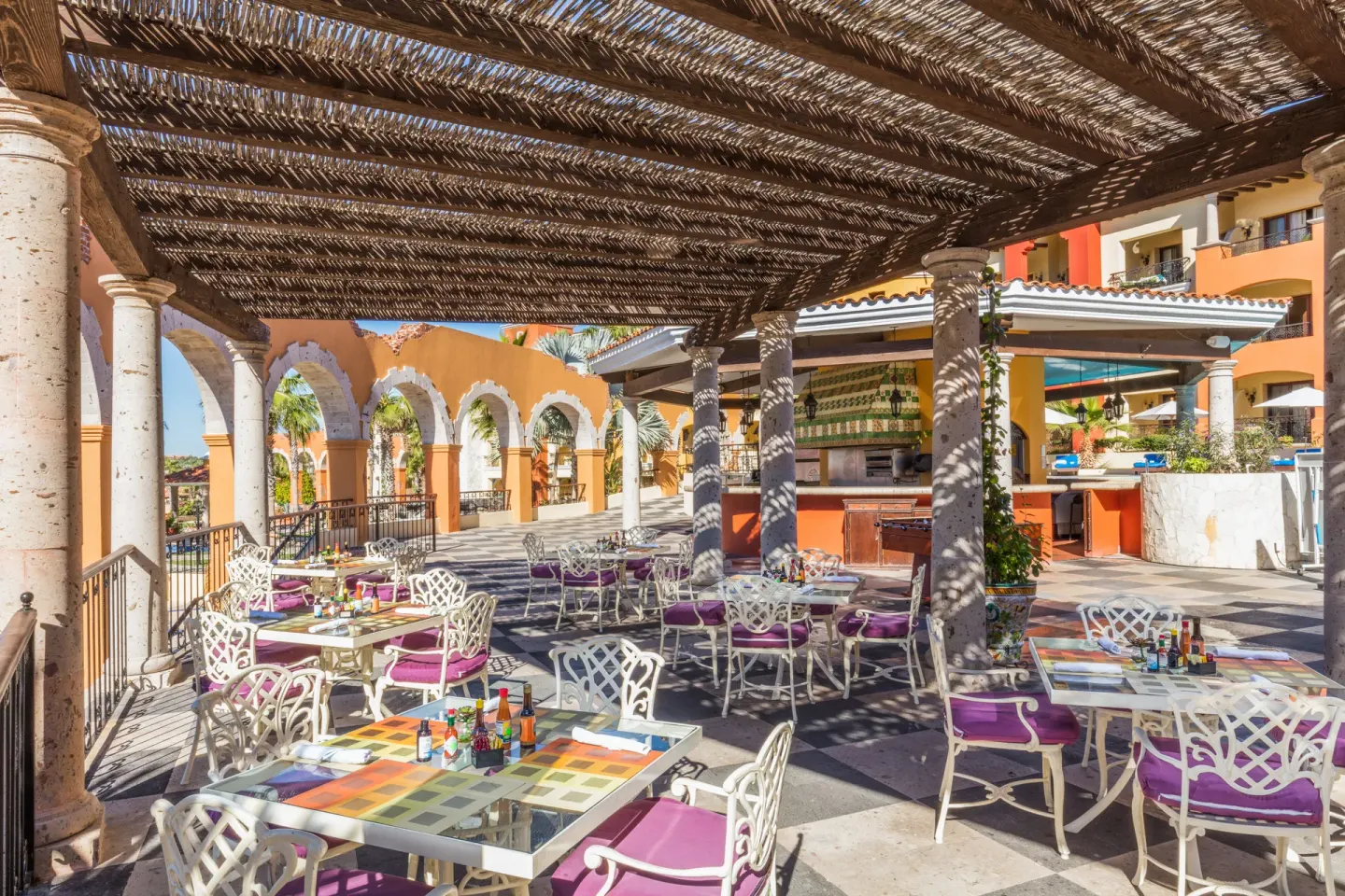 Open-air terrace restaurant seating with purple cushions at El Encanto at Hacienda Encantada.