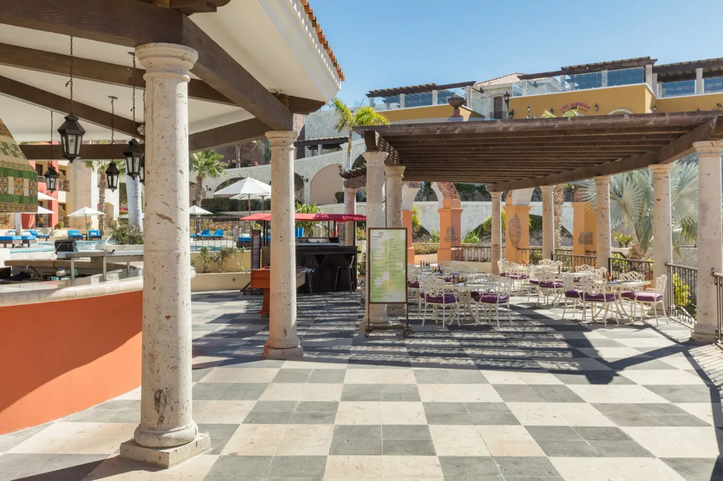 Poolside dining terrace with bar counter and shaded tables at El Encanto at Hacienda Encantada.
