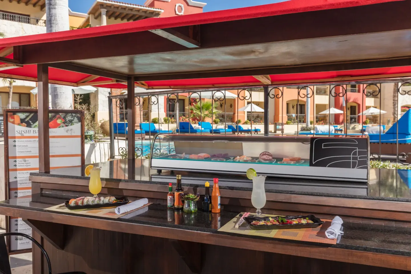 Poolside sushi bar at El Encanto at Hacienda Encantada with counter seating and prepared plates.