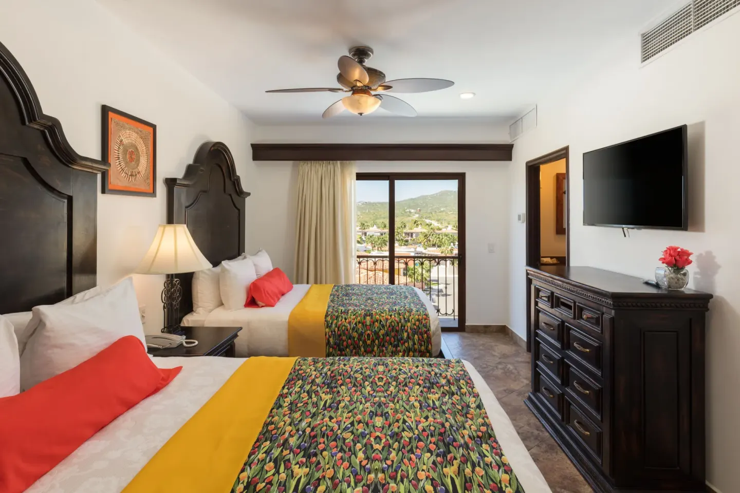Bedroom with two beds and balcony view in a Premium Suite at El Encanto at Hacienda Encantada.