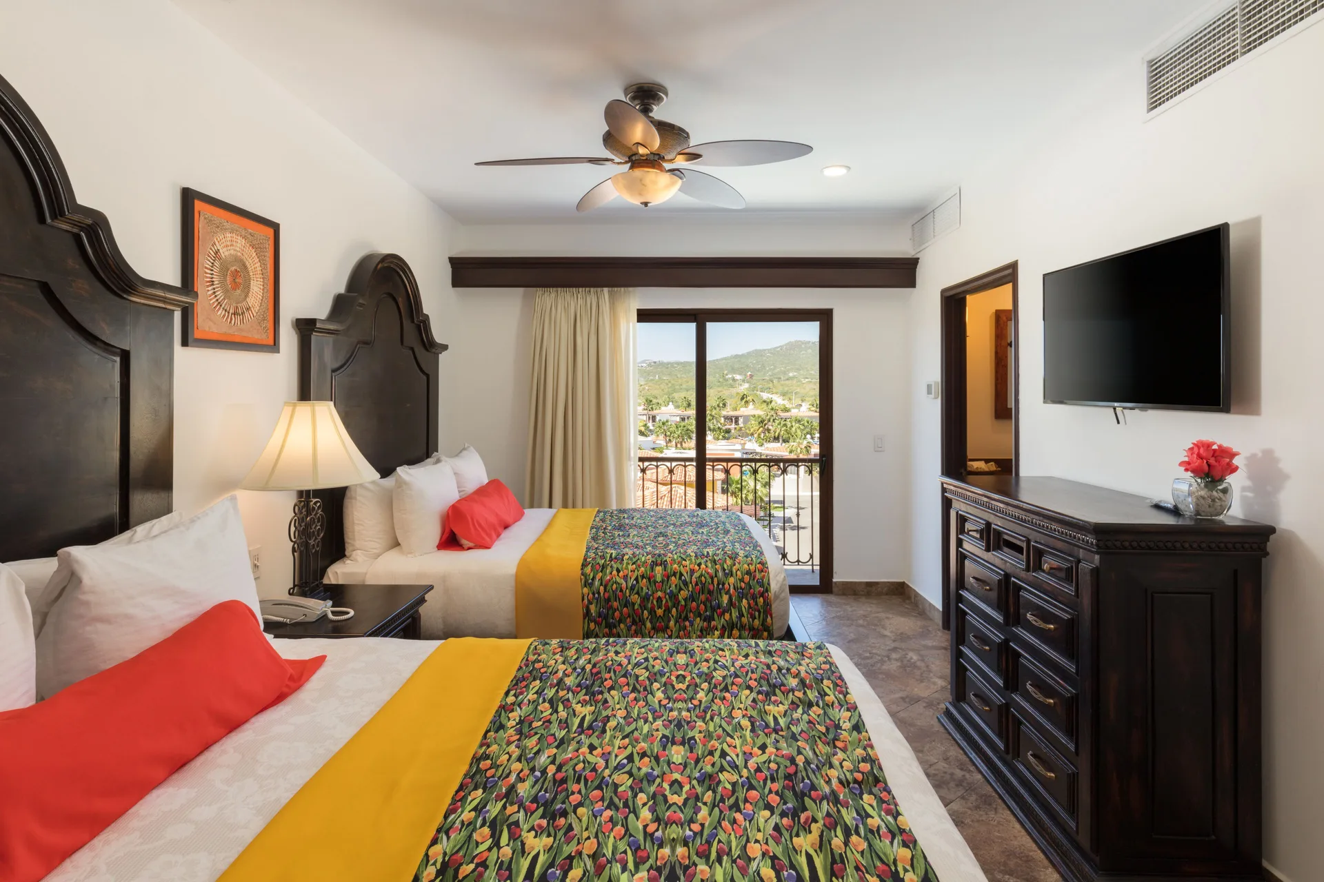 Bedroom with two beds and balcony view in a Premium Suite at El Encanto at Hacienda Encantada.