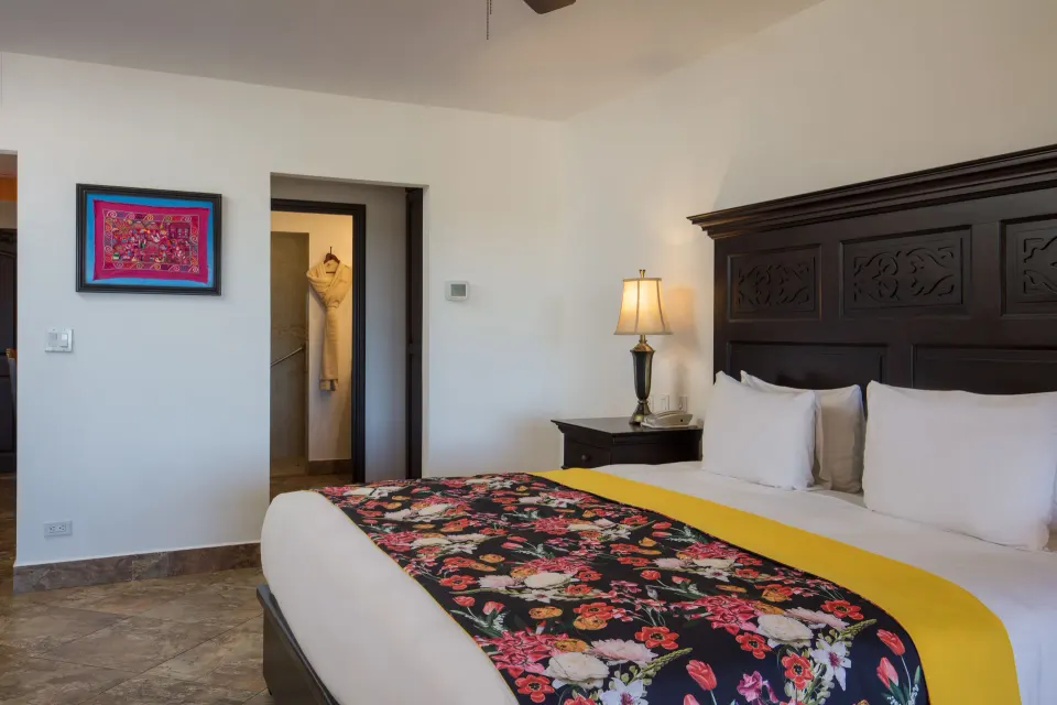 Studio Garden View king bed with floral runner and robe visible at El Encanto at Hacienda Encantada.