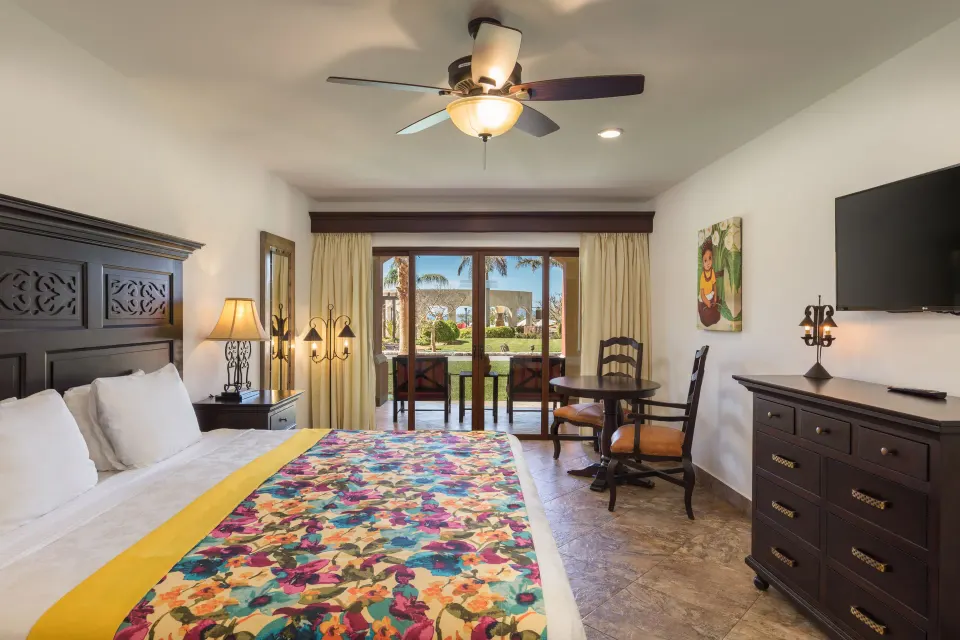 Studio Garden View king bed, desk, dresser, and patio doors at El Encanto at Hacienda Encantada.
