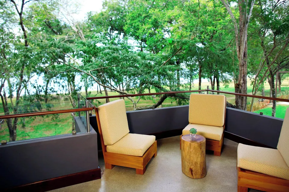 Private balcony seating overlooking trees at El Mangroove Papagayo