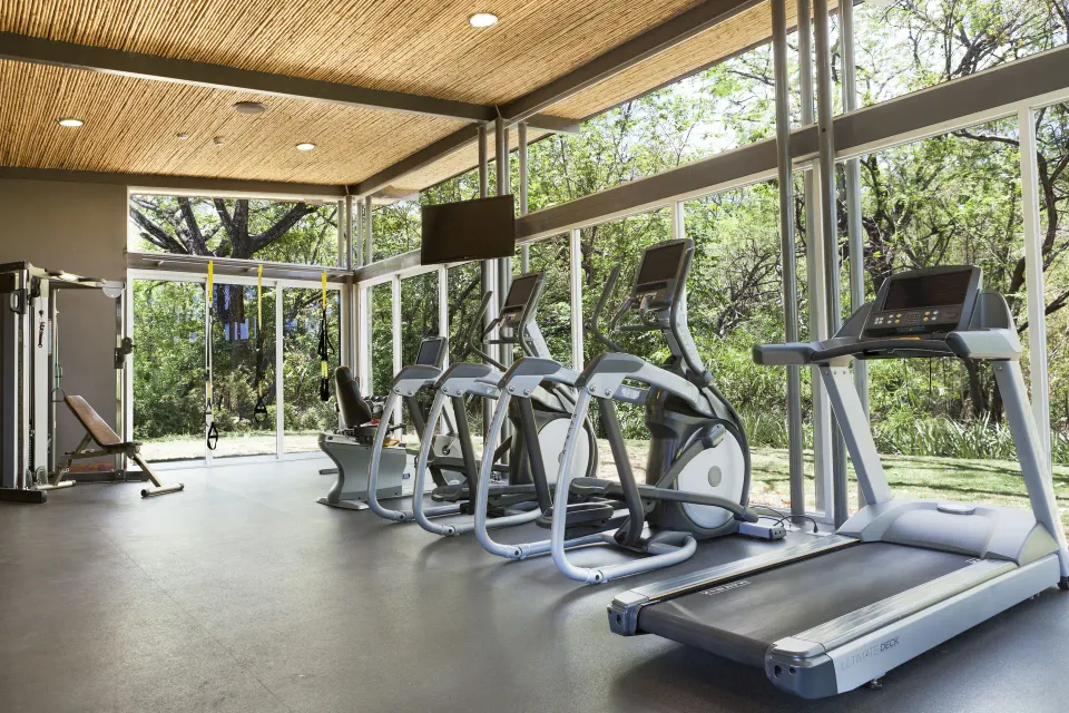 Resort fitness center with treadmills and view of trees at El Mangroove Papagayo