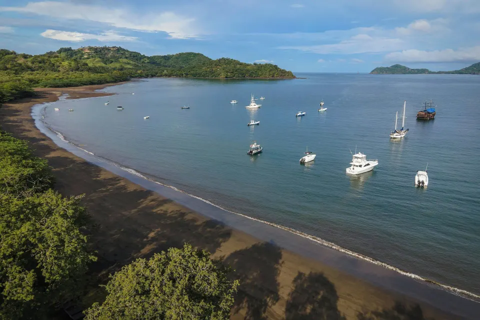 Sandy bay and anchored boats off the shore near El Mangroove Papagayo.