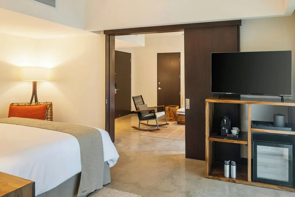 Partial view of bed and TV cabinet with minibar at El Mangroove Papagayo