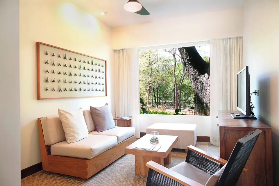 Living area with sofa and large window at El Mangroove Papagayo