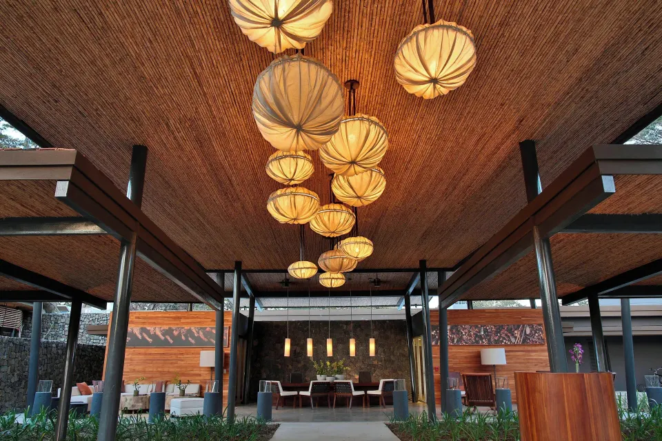 Open-air lobby with cluster of pendant lanterns at El Mangroove Papagayo