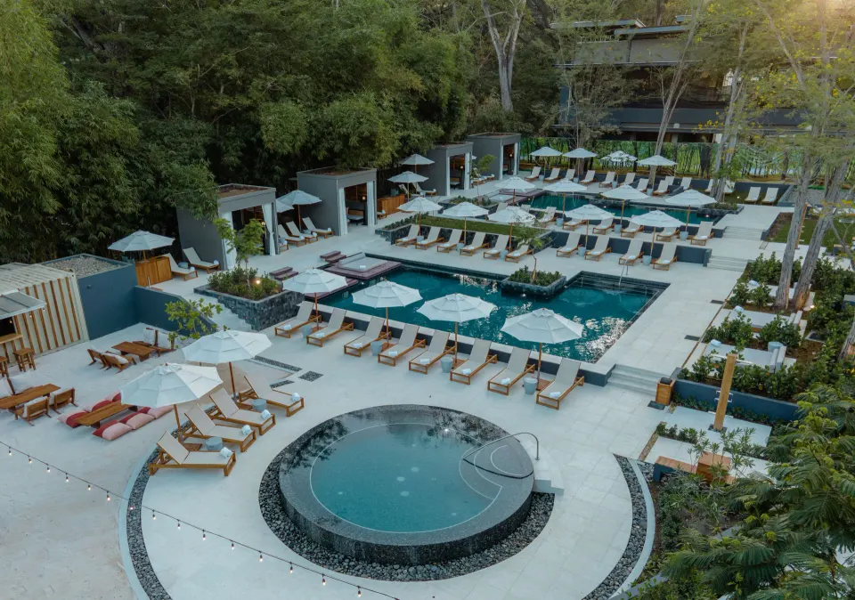 Aerial view of the resort pool area with round spa and many loungers at El Mangroove Papagayo