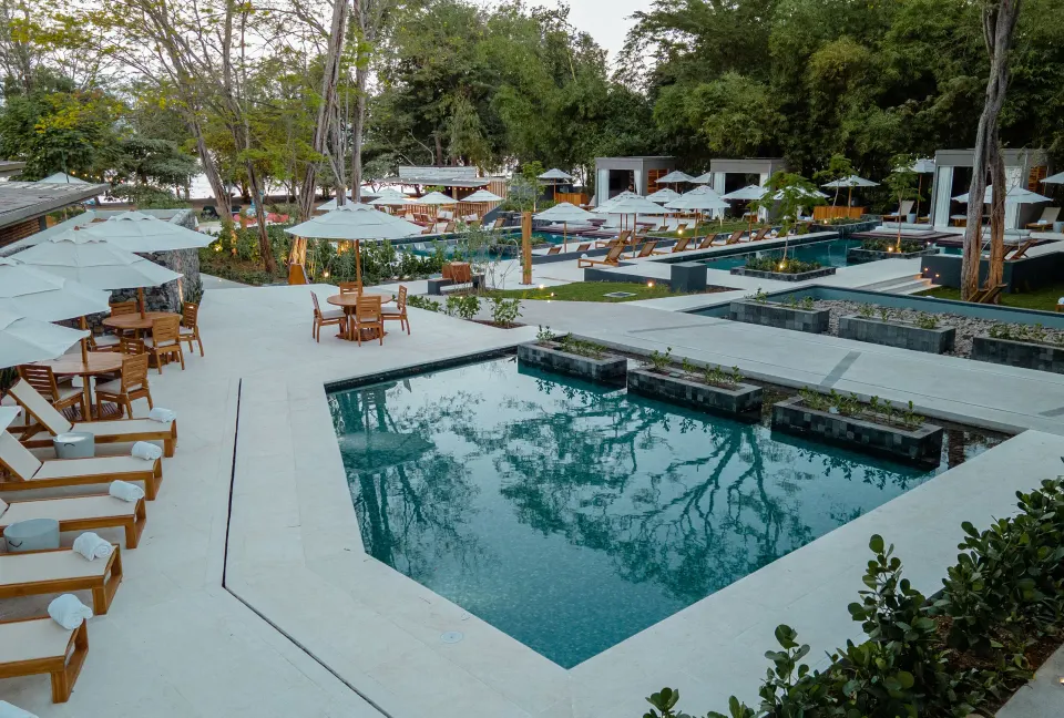 Series of modern plunge pools with loungers and umbrellas at El Mangroove Papagayo.