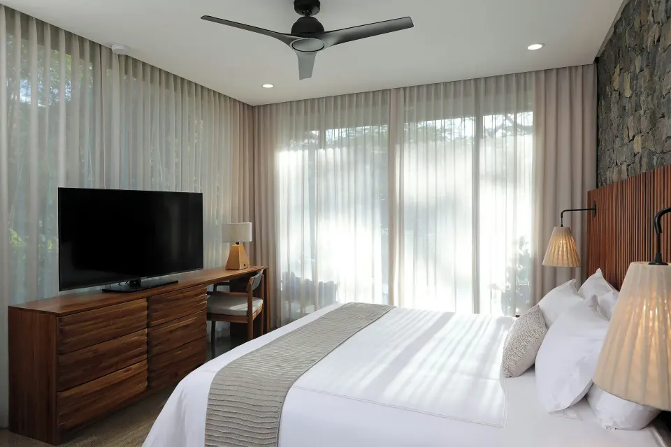Contemporary king bedroom with stone accent wall at El Mangroove Papagayo