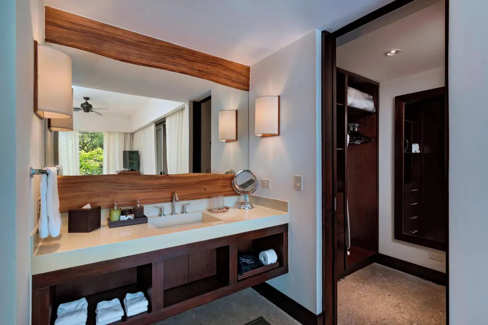 Single-sink vanity and walk-in closet view in a guest suite at El Mangroove Papagayo