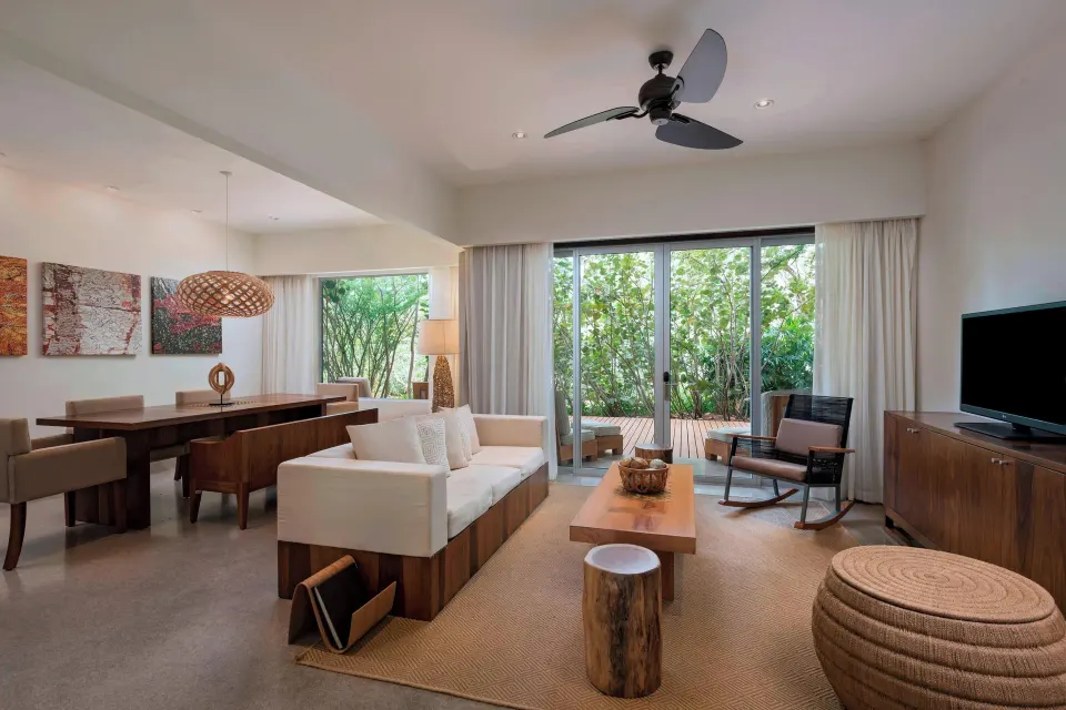 Spacious suite living and dining area with glass doors at El Mangroove Papagayo