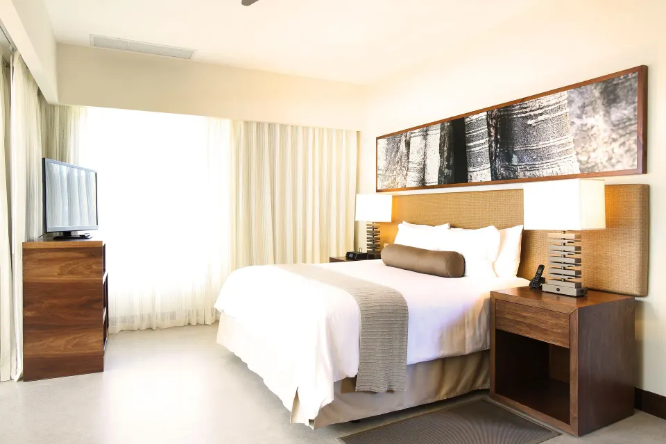 Guest room with king bed, bedside lamps and TV at El Mangroove Papagayo
