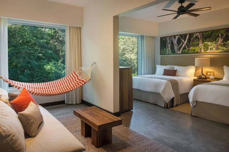 Spacious twin and sofa area with hammock in a guest room at El Mangroove Papagayo