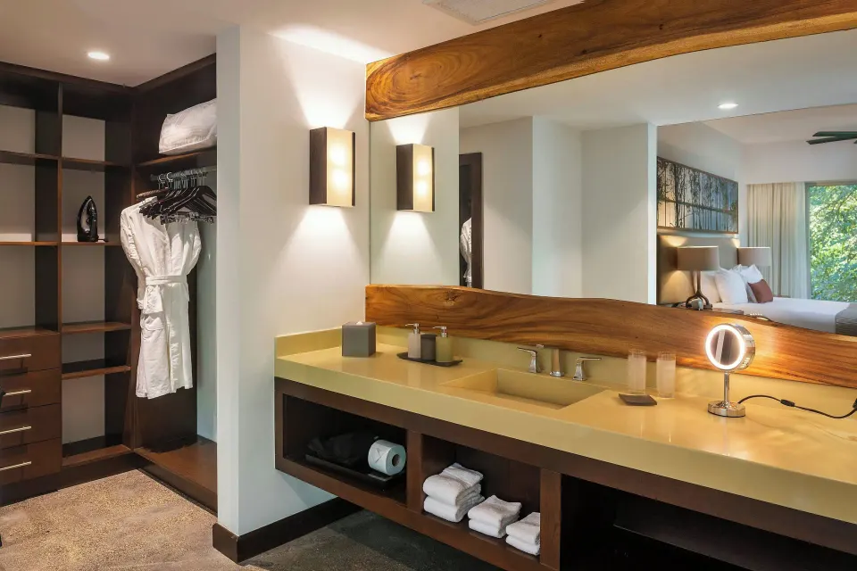 Vanity, robe and partial bedroom view in a guest suite at El Mangroove Papagayo