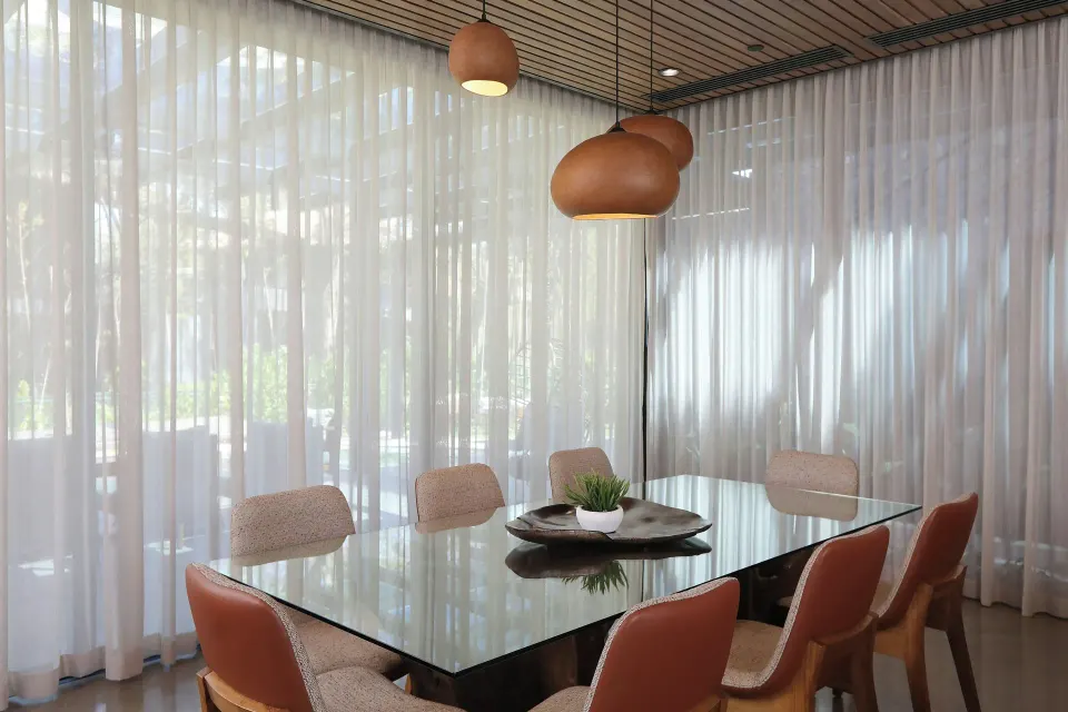 Glass dining table with pendant lights at El Mangroove Papagayo
