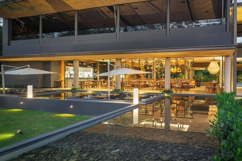 Evening exterior of open restaurant reflected in shallow water at El Mangroove Papagayo