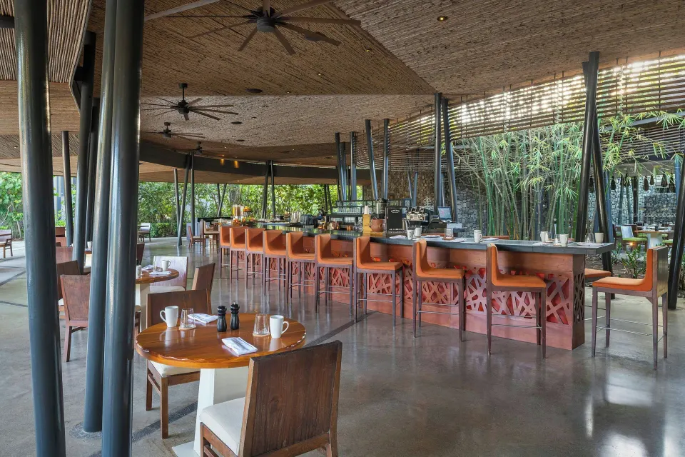 Indoor dining room with long bar and high stools at El Mangroove Papagayo