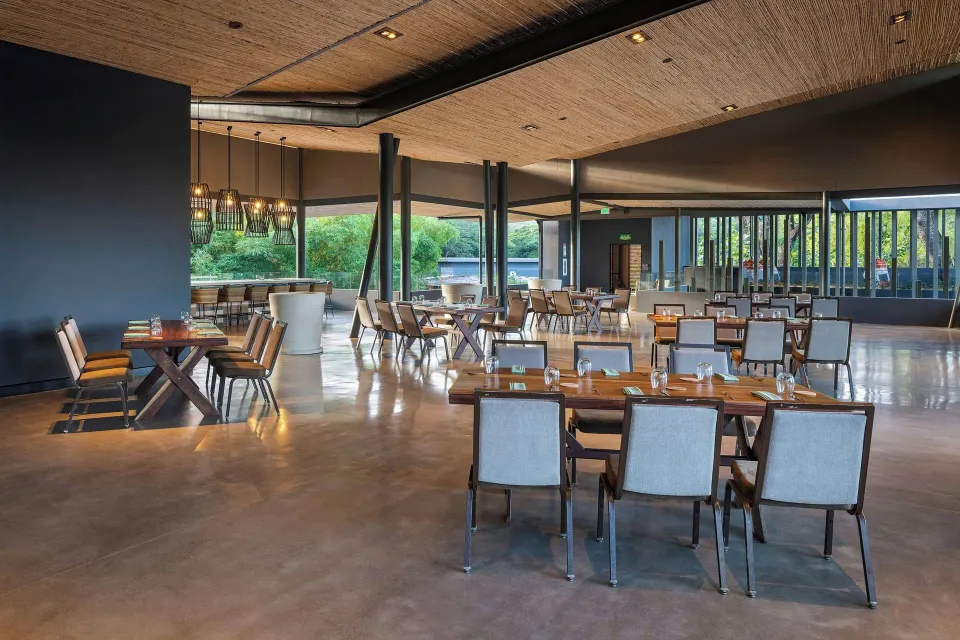 Large open-plan restaurant with tables and pendant lights at El Mangroove Papagayo