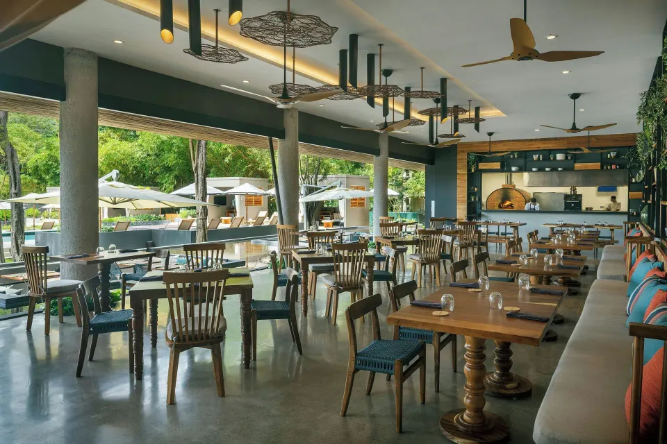 Bright poolside restaurant terrace with tables and umbrellas at El Mangroove Papagayo