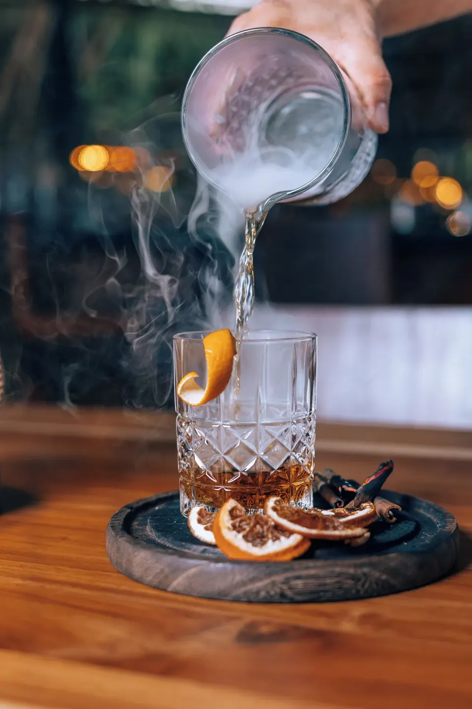 Smoke poured into a rocks glass with citrus garnish at El Mangroove Papagayo