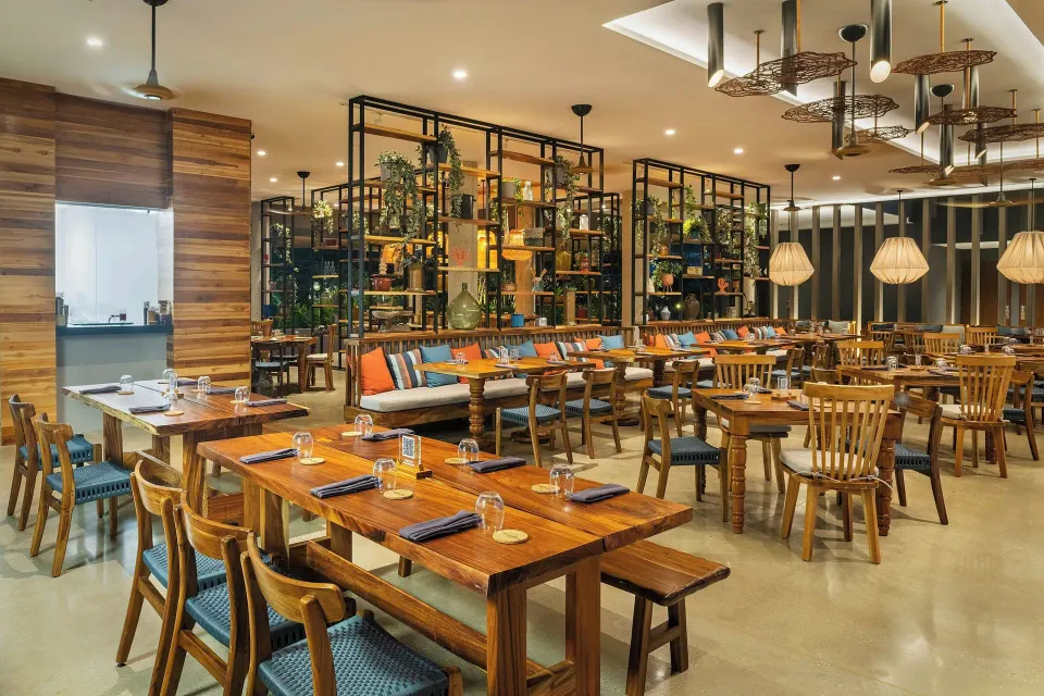 Spacious restaurant interior with mixed seating and decorative shelving at El Mangroove Papagayo
