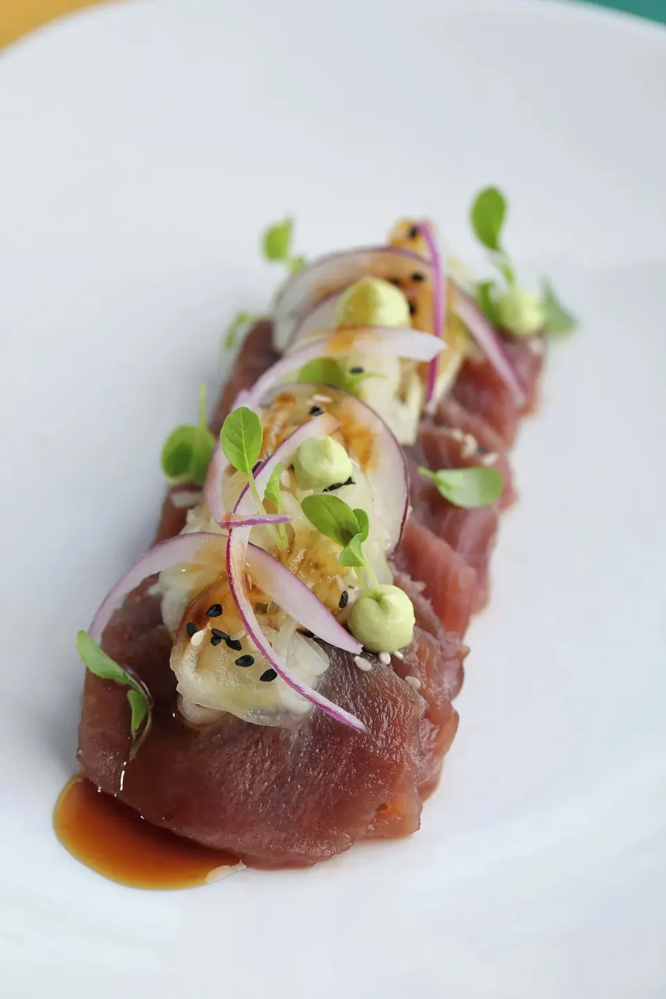 Plated tuna sashimi with microgreens on a white plate at El Mangroove Papagayo