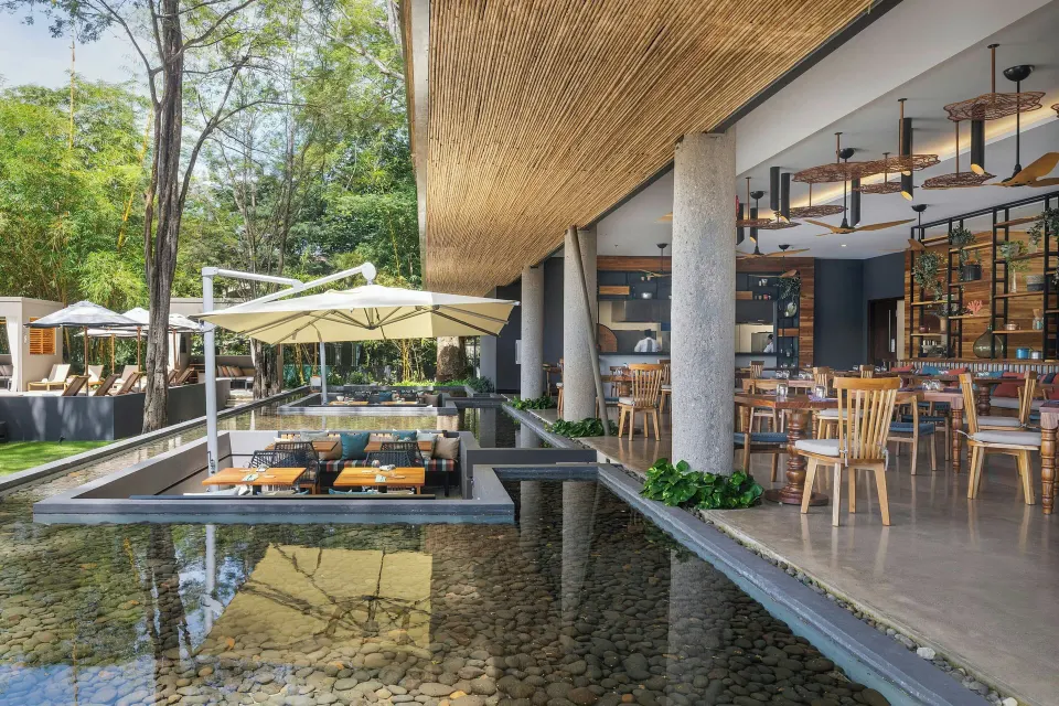 Waterside terrace dining with sunken seating platforms at El Mangroove Papagayo